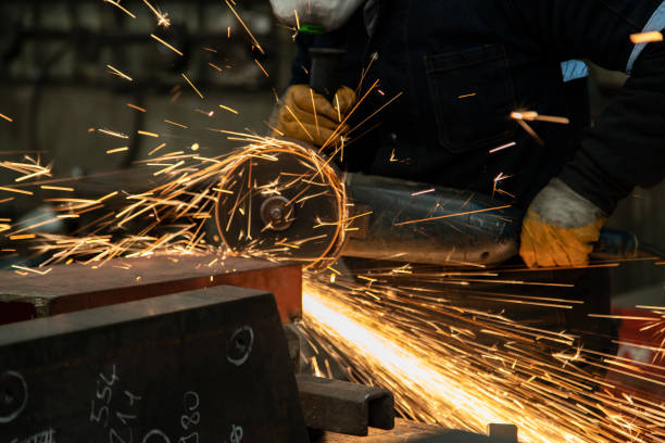 istock Worker man working with electric grinder tool on steel structure in factory. 1341289335