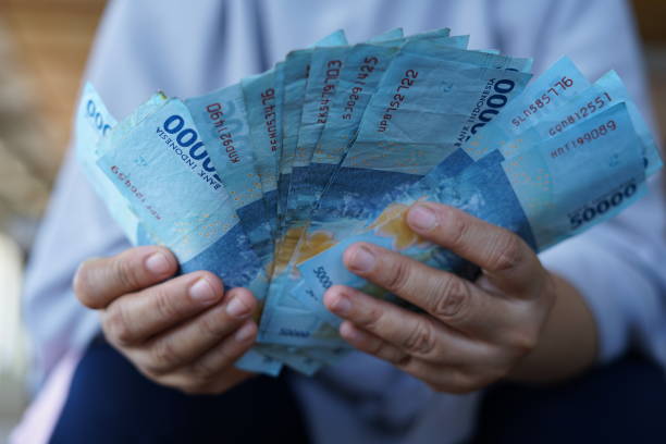 istock Holding a lot of rupiah banknotes 1341289485