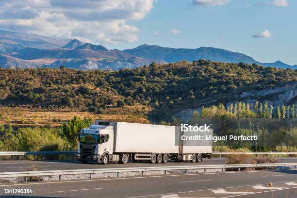 Refrigerated Megatrailer Truck Driving On The Highway With Sierra Nevada In The Background Stock Photo - Download Image Now
