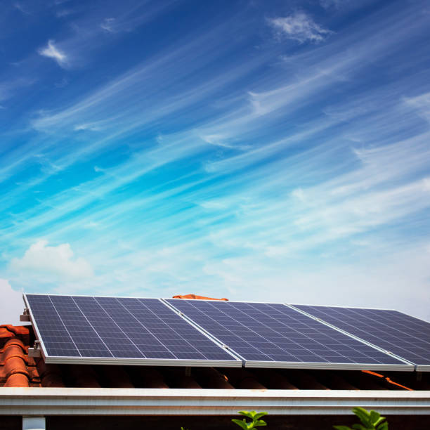 Solar panels on the red roof in a sunny and cloudy day. Photovoltaic instalation image. stock photo