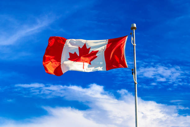 istock Canadian flag against blue sky 1341293020