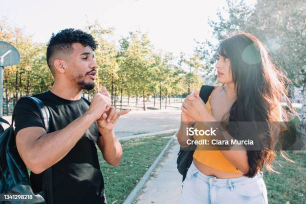 Sign Language 2 Hispanic And African American Student Friends Deaf Talking With Nonverbal Communication Stock Photo - Download Image Now