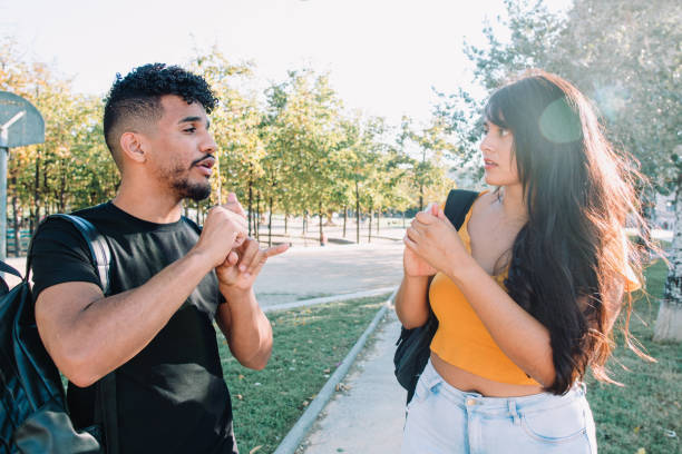 sign language: 2 hispanic and african american student friends deaf  talking with nonverbal communication. - sign language imagens e fotografias de stock