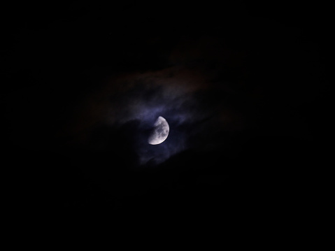 haunting night sky with full moon among storm clouds