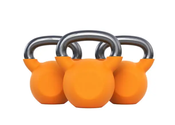 Photo of Three orange kettlebells isolated on a white background