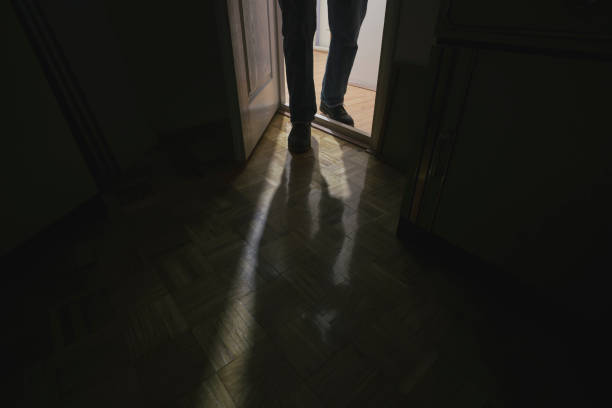 Adult man sneaking in dark house room Suspicious man entering room with lights turn off human limb stock pictures, royalty-free photos & images