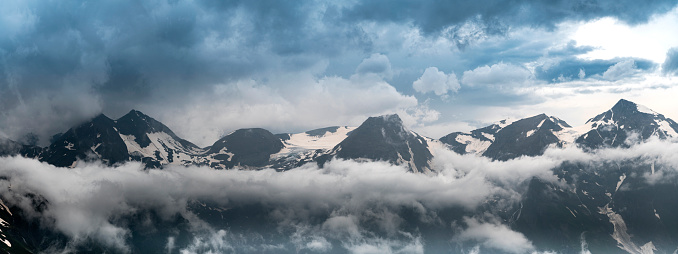 Wide Panorama of Grossglockner Peak in Austria Alps. Dramatic Mountain Above Clouds and Fog.