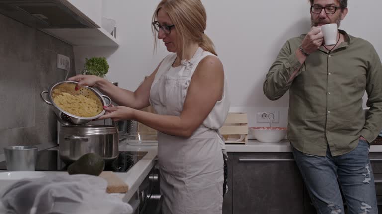 Woman pouring bow tie pasta in a pot to cook for dinner