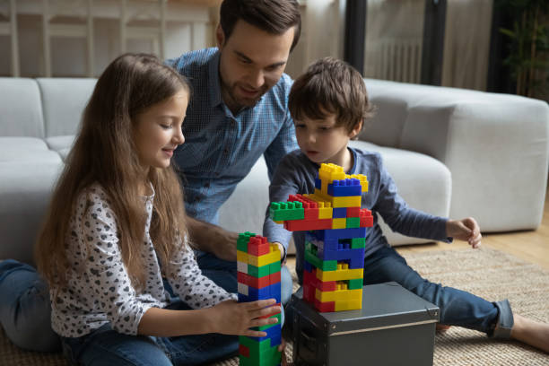 istock Dad teaching son and daughter to build tower from blocks 1341308125
