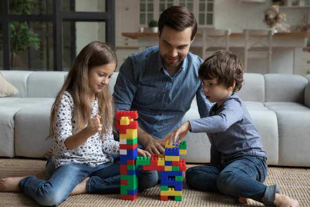 istock Happy dad and two children playing together on warm floor 1341308131