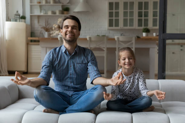 istock Happy calm dad and daughter meditating at home 1341308145