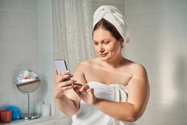 istock Woman making selfie on mobile phone while sitting in bathroom 1341308274