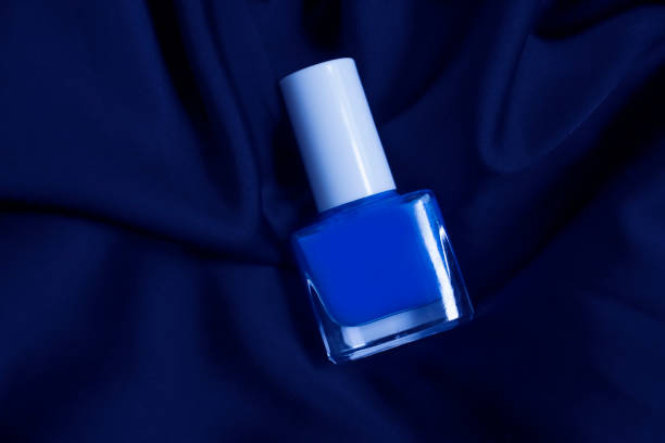 Bottle of nail polish on light blue background, closeup. Space for text