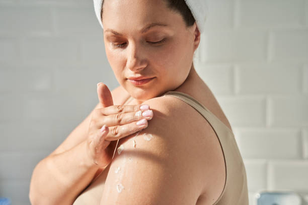 istock Oversize woman applying cosmetic cream on shoulder 1341310257
