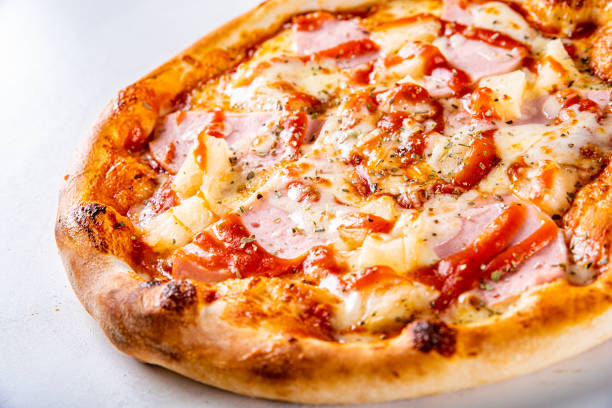 istock fast food. Hawaiian pizza with pineapple, ham, chicken, cheese, and vegetables 1341310575