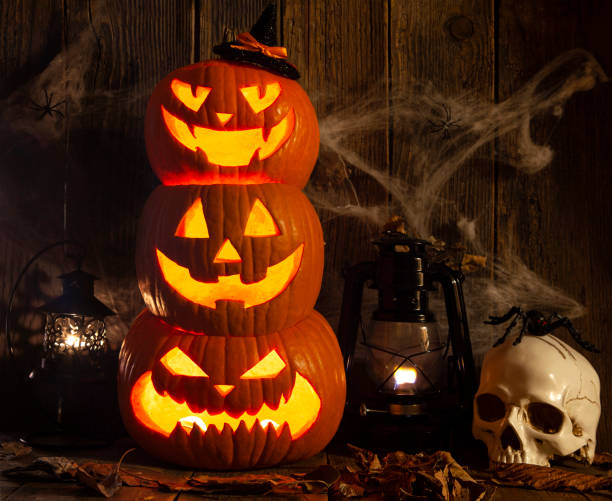istock Halloween Jack-o-Lantern Pumpkins on rustic wooden background 1341311423