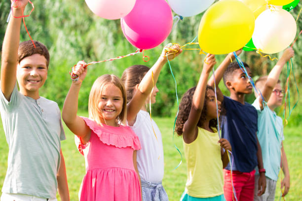 istock Children with balloons on field 1341311966