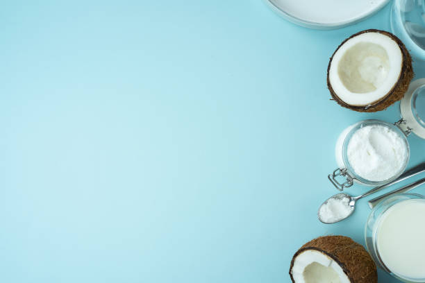 코코넛 제품. 고기가 반으로 자른 오픈 코코넛, 유리 항아리에 코코넛 파우더, 푸른 배경에 우유를 심는 다. 등등 투영. 공간을 복사합니다. 개념 대체 우유, 식물성 - vegeterian exoticism food freshness 뉴스 사진 이미지