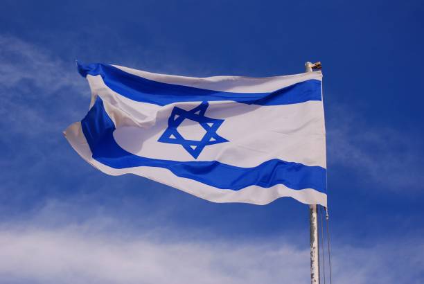 istock Israeli flag blowing in the wind, blue sky 1341316901