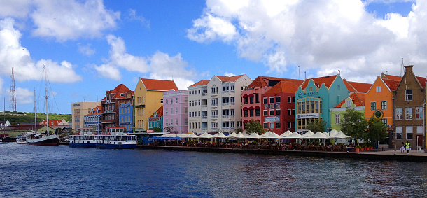 Willemstad, Curacao - December 2 2014 - Famous colorful houses at the Handelskade. The Dutch colonial houses at Punda. In 1997 the historic area of Willemstads inner city and the harbour was awarded UNESCO World Heritage status.