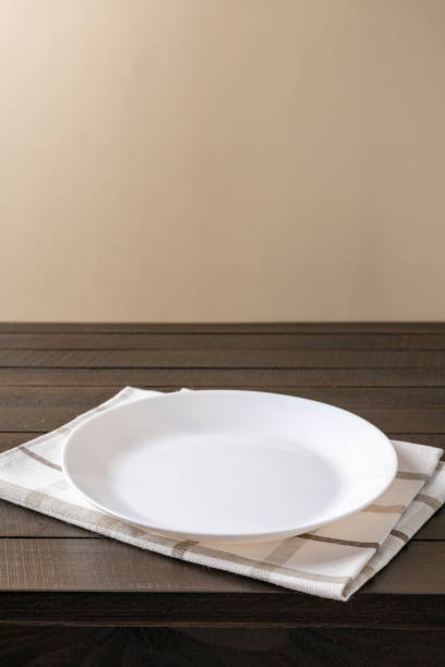 istock Empty plate on napkin on wooden table over grunge blue background. 1341325299