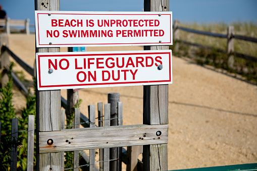 Warning sign alerting people of unguarded beach.