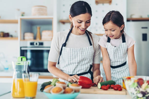 istock Mom and girl making salad 1341334832