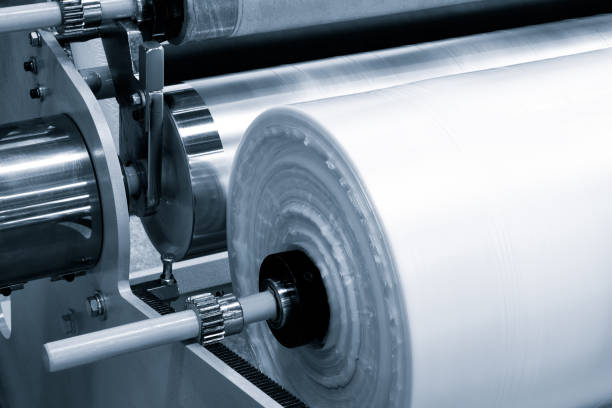 istock The operation of automatic plastic bag production machine with lighting effect. Close-up of the roller of the plastic bag production machine in the light blue scene. product packaging concept 1341334897