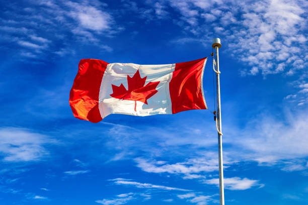istock Canadian flag against blue sky 1341336967