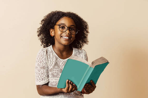 happy child with goggles holding a blue book.