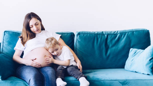 istock Cute small boy talking with his pregnant mother 1341347084