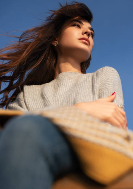 istock Thoughtful woman looking away against blue sky 1341347320