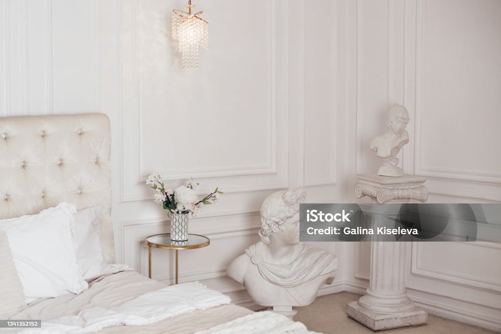 Beautiful bedroom in beige colours Beautiful bedroom in beige colours with antique sculptures Sculpture Stock Photo