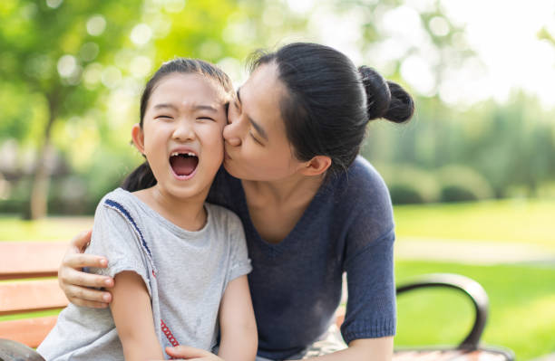 istock Mother kissing daughter 1341357513