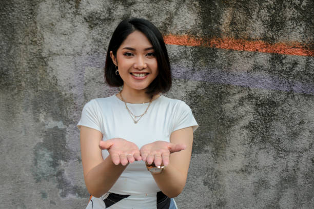 istock Smile Asian women smiling show palm in front for present 1341361201