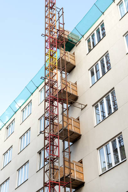 istock Construction freight elevator attached to the renovated european building. Construction site work equipment 1341362224