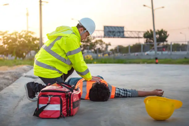 Photo of Accident at work of construction labor people, Basic First aid and CPR Training at outdoor. Heat Stroke or Heat exhaustion in body concept.