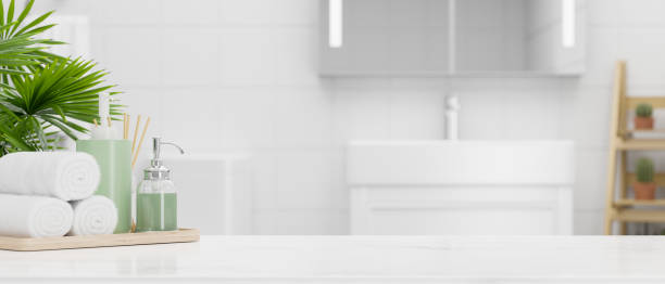istock Close up tabletop with mockup space and bath accessories over modern bright bathroom 1341371643