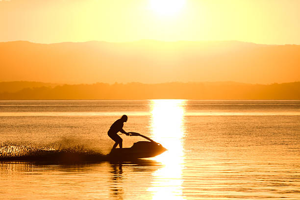 istock Silhouette of man riding a water scooter 134137275