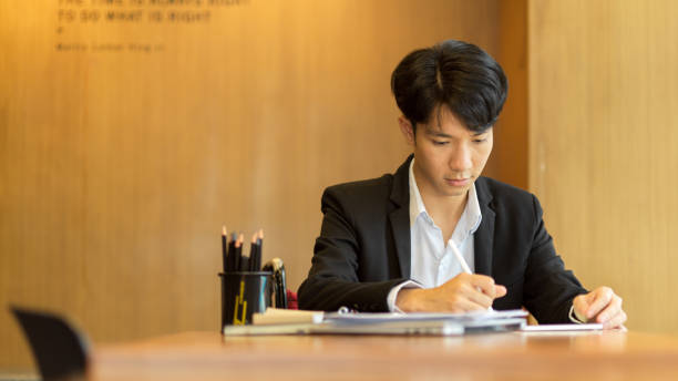 istock Businessman signing a document, writing down on paper 1341373381