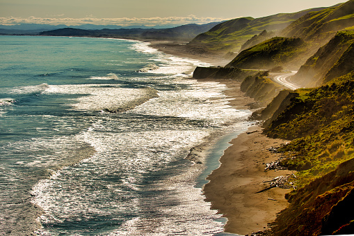 The ocean spray from the crashing waves hitting the coastal road and seaside cliffs off the Gisborne Coast