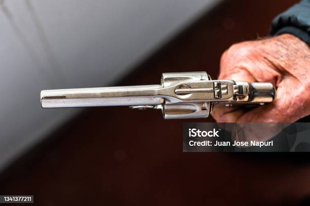 An Old Hand Holding An Antique Revolver In A Shooting Position Stock Photo - Download Image Now