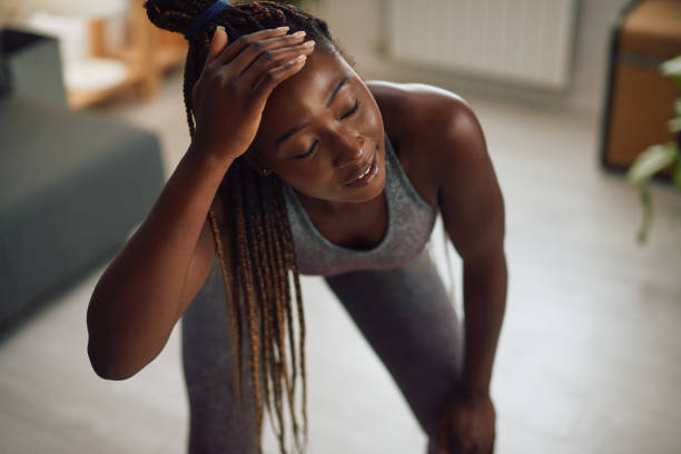 istock Tired black female athlete taking a break while exercising at home. 1341378756