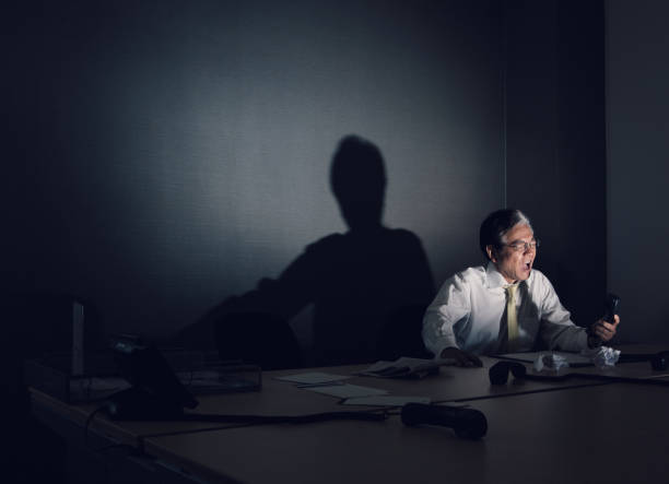 японский корпоративный босс кричит по телефону - senior men businessman portrait dark стоковые фото и изображения