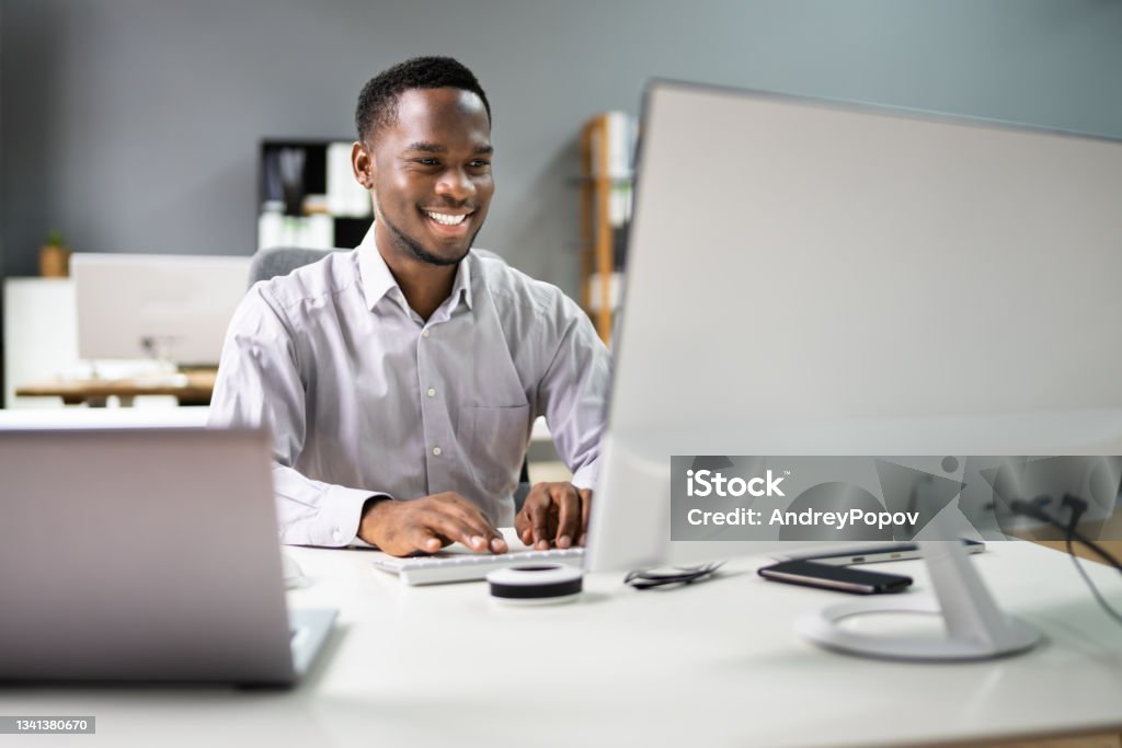 Happy Professional Man Employee Using Computer Happy Professional Man Employee Using Computer For Work Desktop PC Stock Photo