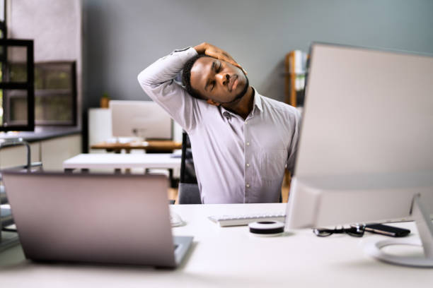 istock Employee Stretching At Office Desk 1341380686