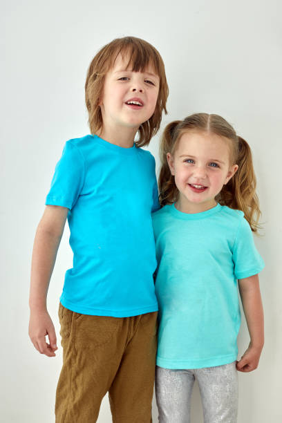 istock Happy kids in blue t shirts white wall 1341383090