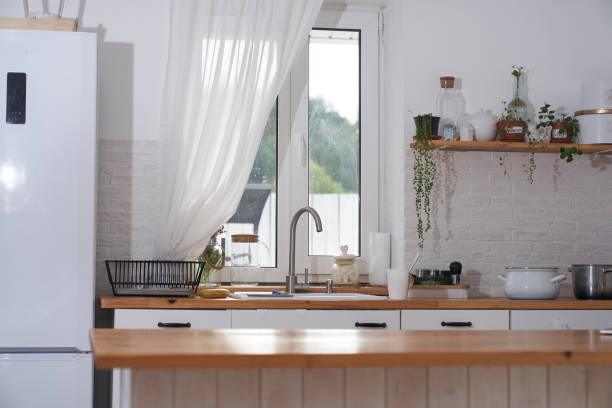 istock Cozy modern interior of a Scandinavian-style kitchen with a dining area, white modern interior, casual still life, coronavirus quarantine, household chores 1341383285