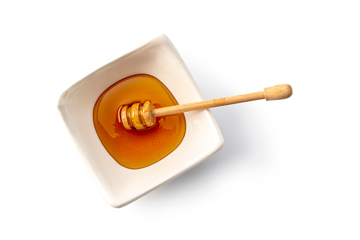Bowl of honey isolated on white background , studio shot, high angle view.