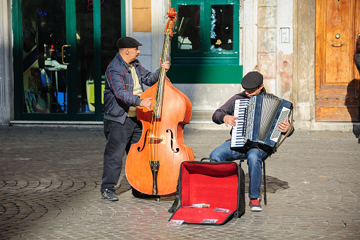 Rome, Italy - January 01, 2013: two musicians play double bass and an accordion near Santa Cecilia in Trastevere Church for tips and also to promote their song on CD.
